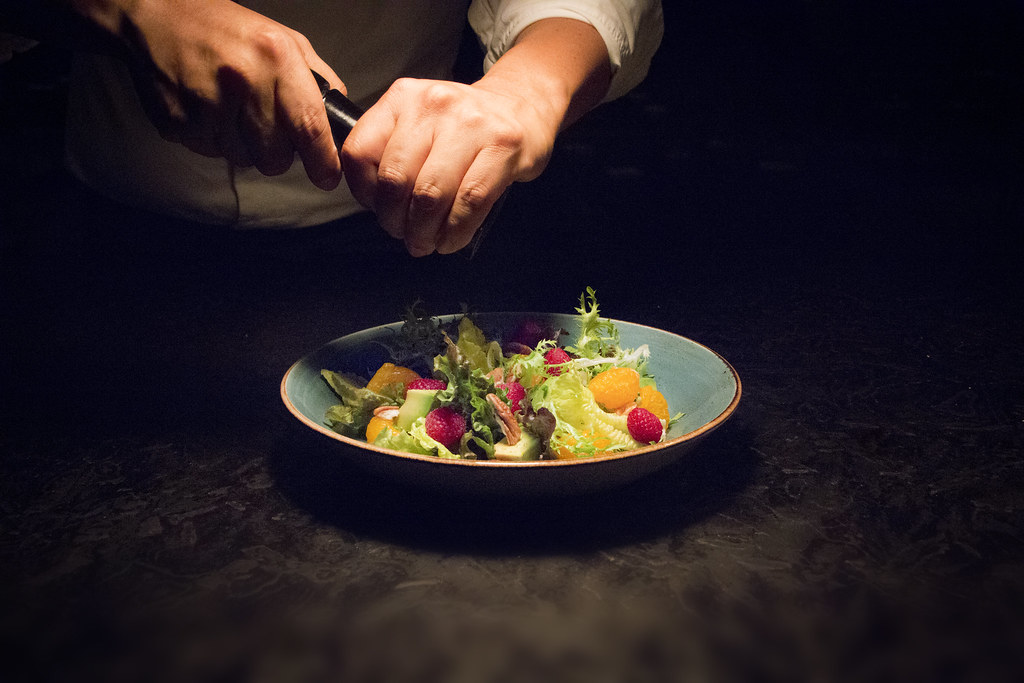 Chef preparando un platillo para una sesión de fotografía gastronómica en restaurante hotelero.